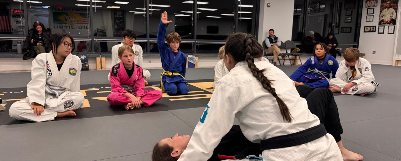 Youth BJJ Class at Pedro Sauer Academy of Self-Defense, Herndon VA. - Pedro Sauer Academy Youth Brazilian Jiu-Jitsu gi class at Pedro Sauer Academy of Self-Defense in Herndon, VA, with Coach Nina demonstrating a side-control escape.