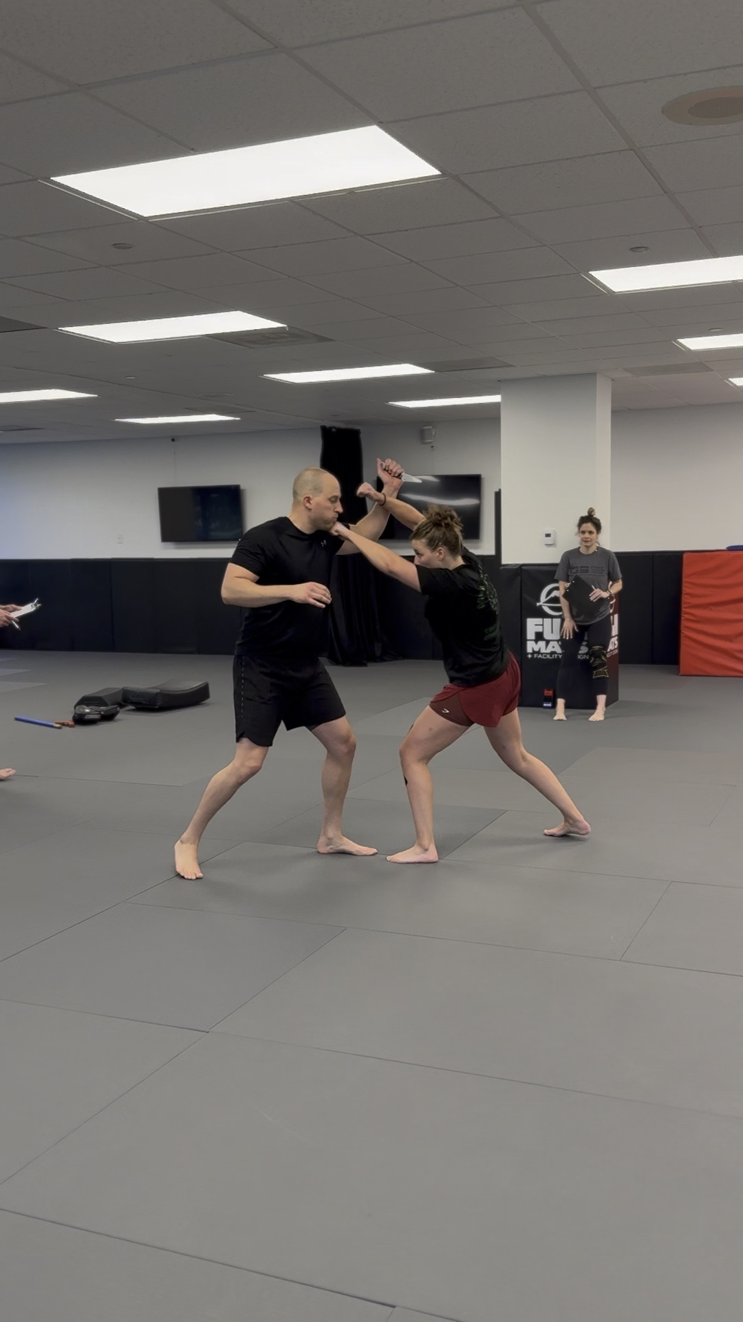 Krav Maga student practicing a striking and defense drill with an instructor at Pedro Sauer Academy