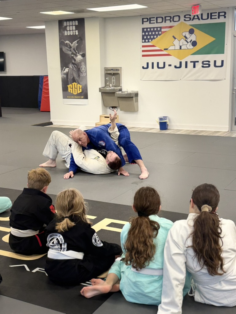 Youth students watching a Jiu-jitsu technique demonstration at Pedro Sauer Academy