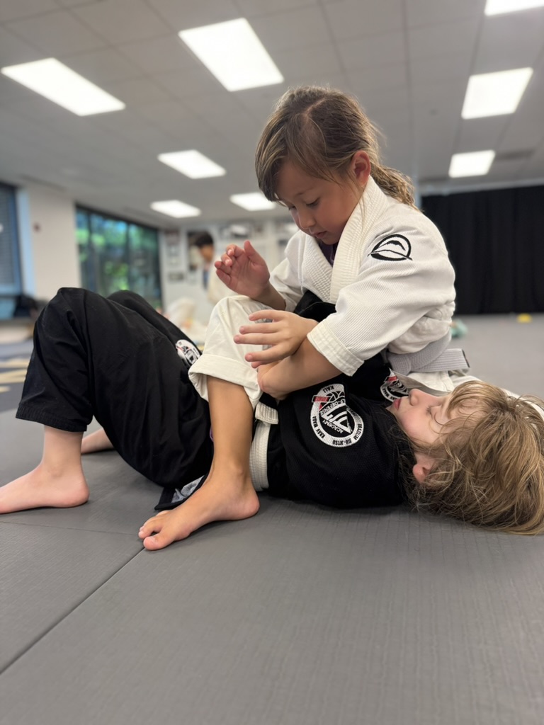 Two Youth Jiu-jitsu students practicing a supervised partner technique at Pedro Sauer Academy